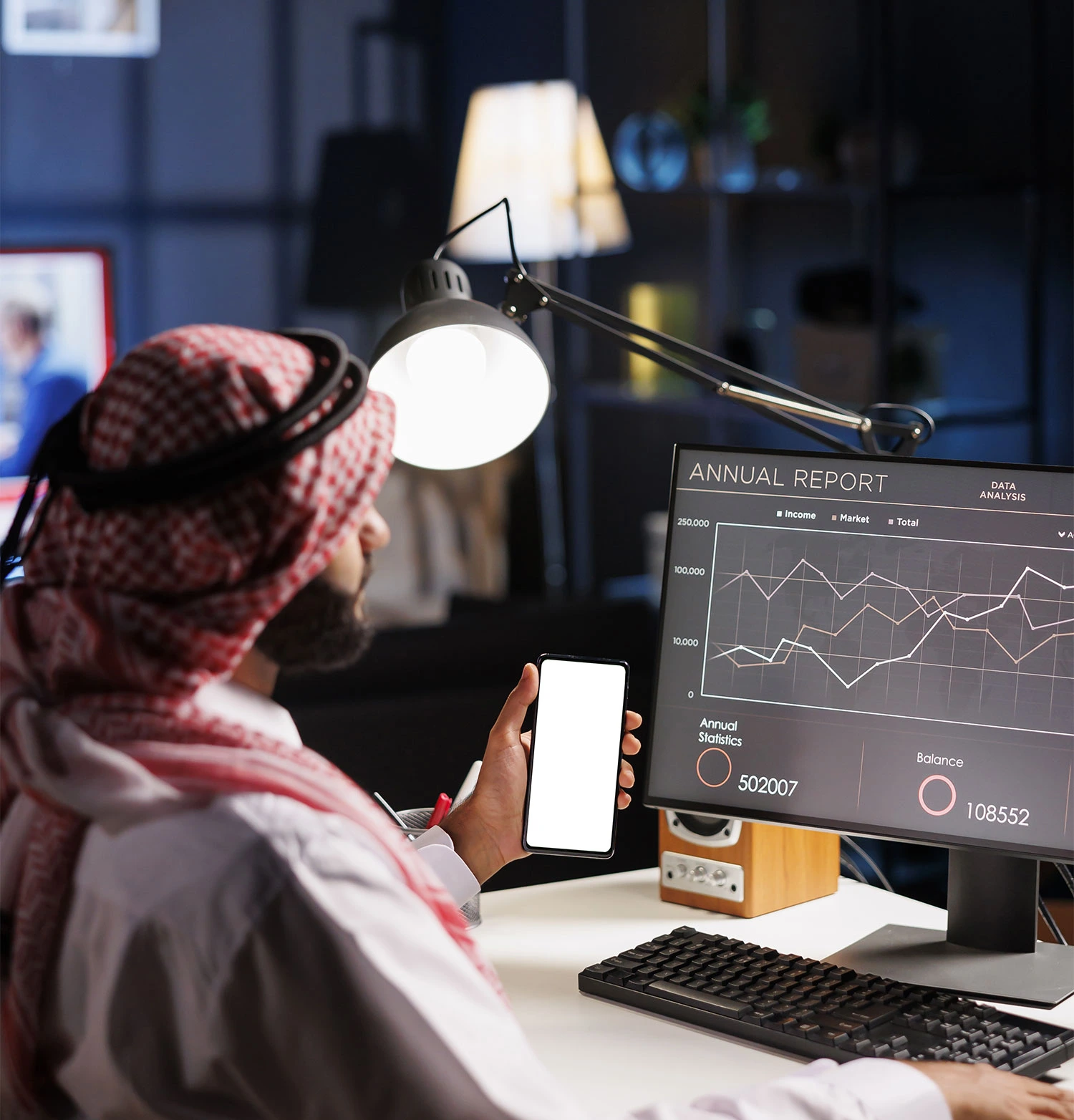 A man in a headscarf is focused on using a computer, likely working on advanced SEO services.